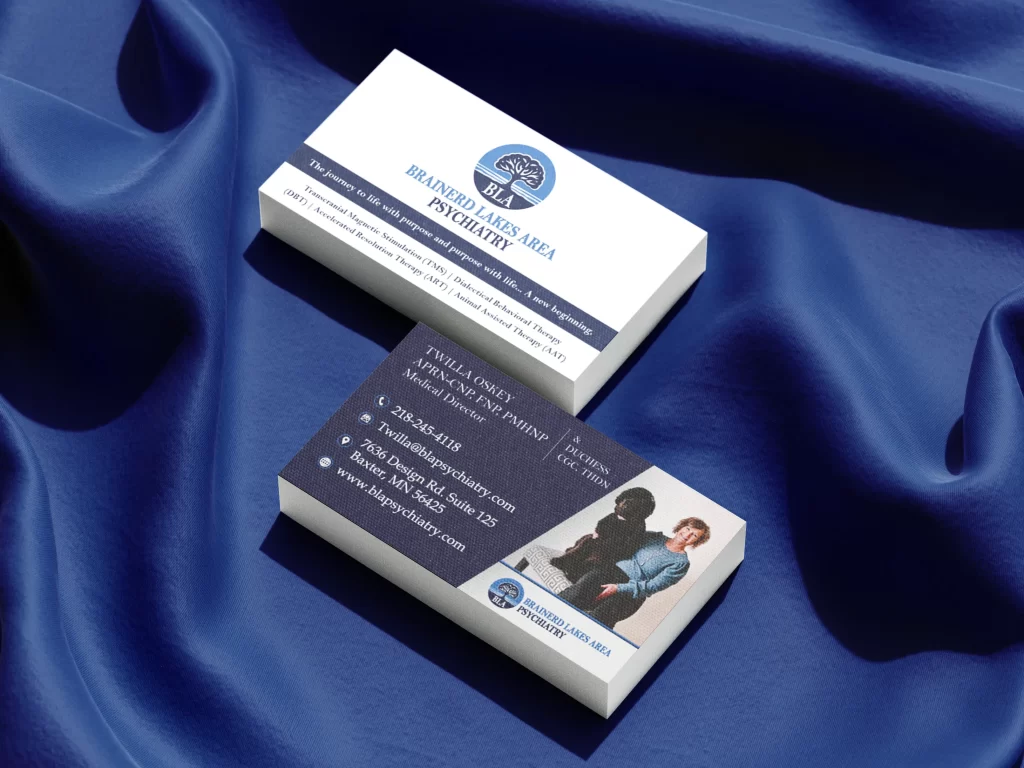 Business card design mockup for Brainerd Lakes Area Psychiatry, featuring Medical Director Twilla Oskey and her therapy dog, Duchess. The front of the card displays a clean white background with the circular tree-of-life logo and a list of specialized services like TMS, DBT, and Animal Assisted Therapy. The back side uses a professional dark navy textured background with white contact details, a Baxter, MN office address, and a 218 area code phone number. The design emphasizes a compassionate and expert approach to psychiatry.