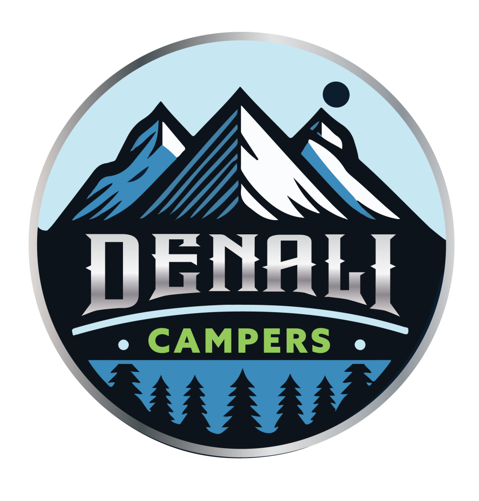 Circular badge logo for Denali Campers featuring a majestic mountain range illustration under a light blue sky with a dark sun or moon icon. The 'DENALI' wordmark is rendered in a bold, metallic silver gradient with a sharp serif typeface. Below, the word 'CAMPERS' is displayed in bright lime green, anchored by a silhouette of evergreen trees against a blue lake background. The entire emblem is enclosed in a thick, metallic silver circular border.