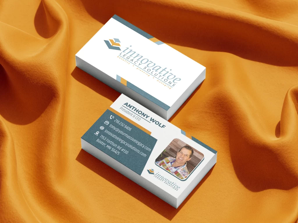 Business card design mockup for Innovative Legacy Solutions, featuring Anthony Wolf, President & CEO. The front card displays a clean white background with a gold and slate blue geometric logo and serif typography. The back card uses a modern split-layout with a slate blue contact section, gold accents, and a rounded-corner headshot of Anthony Wolf. Contact details include a Baxter, MN address, 218 area code phone number, and a professional website URL.
