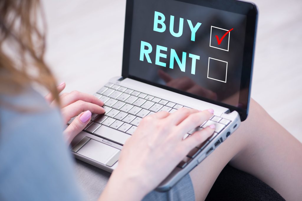 Hands typing on a laptop; the screen shows the words BUY and RENT with a checked option in a checkbox.